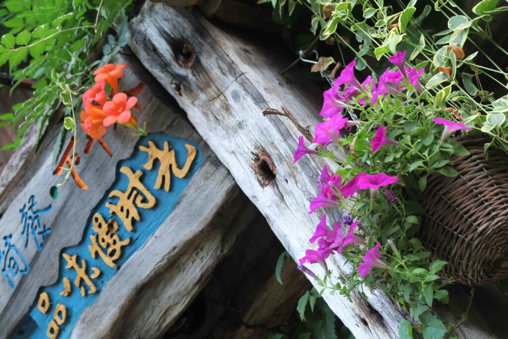 Chinesische Kaligrafie in einem Hauseingang mit Blumen