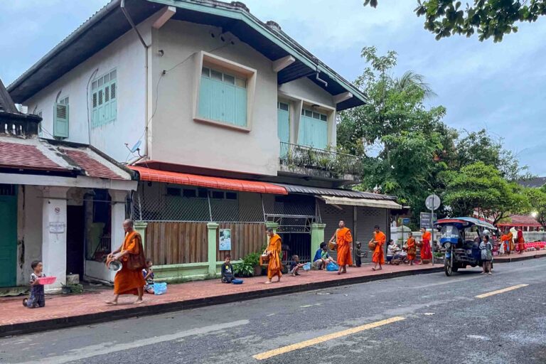 Die Mönche geben von ihren Almosen an arme Kinder ab